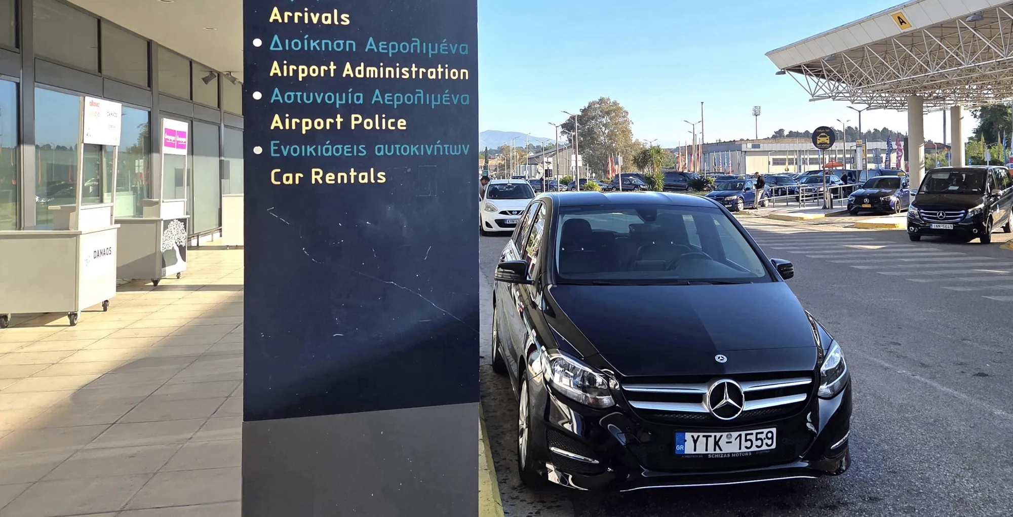 The black Mercedes waiting outside arrivals at Corfu Airport