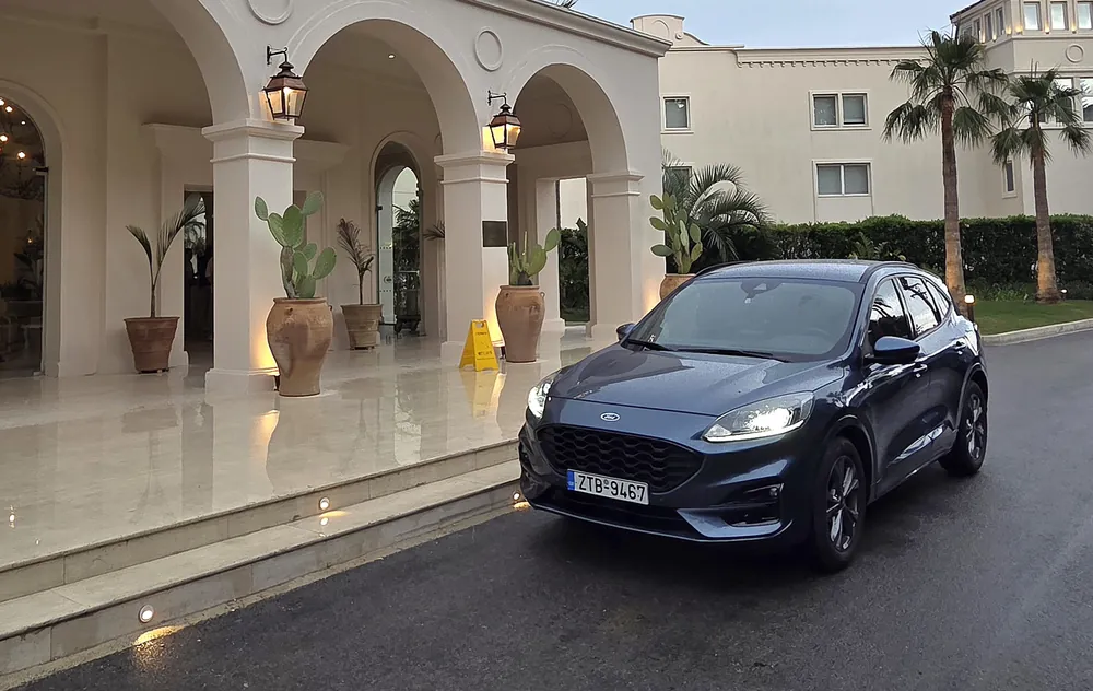 The blue Ford Kuga outside a hotel entrance with arches and palm trees